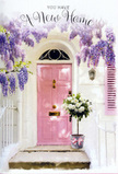 This photograph captures a warm and inviting doorway that could easily be found on a calm Stanmore cul-de-sac, where neighbours know each other and a bouquet on the step never goes unnoticed. At its heart is a pale pink front door, painted in a creamy, pastel shade that glows gently against the clean, whitewashed walls surrounding it. The finish of the door is smooth, catching the light in soft reflections that suggest a bright but not overpowering day, perhaps reminiscent of the soft light that drifts across Stanmore's residential streets near Bernays Gardens. Framing the upper part of the doorway, wisteria flourishes in long, trailing clusters of lavender and lilac. The blooms tumble down in layers, forming a natural curtain that softens the architecture and adds a sense of romantic abundance. Their texture looks almost velvety, and you can almost imagine the subtle perfume hanging in the air. On the doorstep itself, a muted grey metal bucket stands as a sturdy yet understated vessel. From it emerges a lavish gathering of white and cream roses, their full, rounded heads pressed closely together, with some flowers just beginning to unfurl while others are fully open, revealing concentric whorls of petals. Wisps of fresh green foliage break up the ivory tones, adding a gentle movement that mirrors the wisteria's downward flow. A pink ribbon is tied neatly around the bucket, its satin bow and trailing ends softening the metal with a touch of grace. The overall impression is of a heartfelt housewarming arrangement, perfectly suited for a new home near Stanmore Cricket Club or a freshly refurbished flat off Marsh Lane. Everything in the image speaks of optimism, calm celebration, and the quiet comfort of knowing that, with roses on the step, a new address already feels deeply, and beautifully, like home.